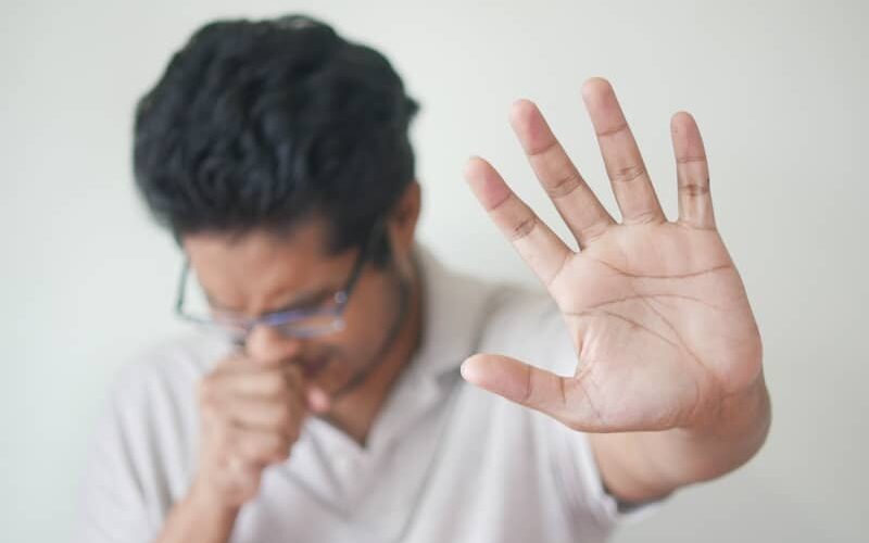 a man holding his hand up in front of his face
